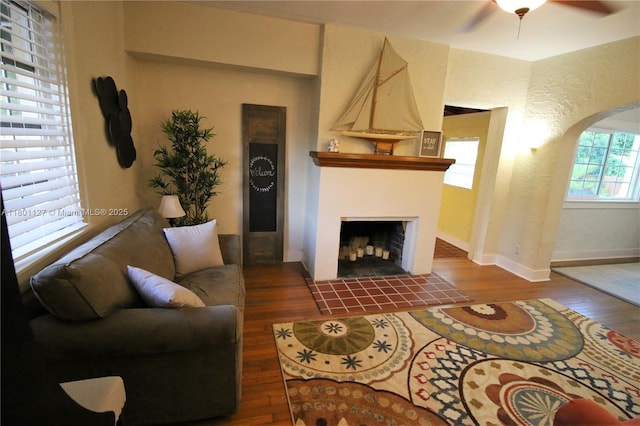 804 SE 10th St, Fort Lauderdale, FL 33316 - living room featuring wood finished floors, arched walkways, a ceiling fan, and a tile fireplace