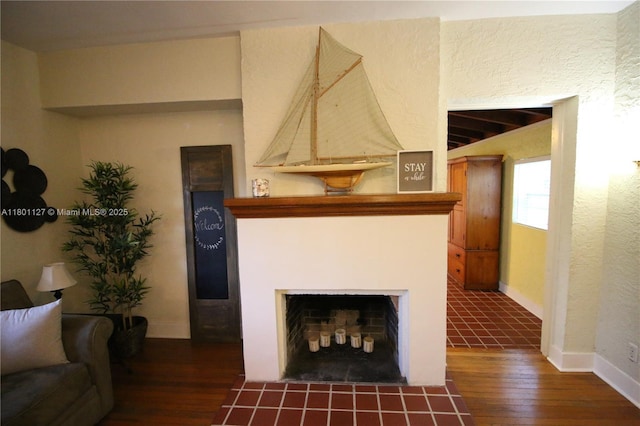804 SE 10th St, Fort Lauderdale, FL 33316 - living area with dark wood finished floors, a fireplace with flush hearth, baseboards, and a textured wall