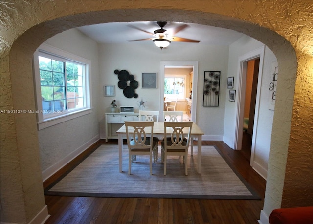 804 SE 10th St, Fort Lauderdale, FL 33316 - dining room with a textured wall, dark wood-type flooring, arched walkways, a ceiling fan, and baseboards