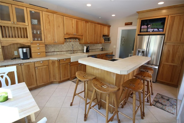 804 SE 10th St, Fort Lauderdale, FL 33316 - kitchen with appliances with stainless steel finishes, a sink, tasteful backsplash, a center island, and tile countertops