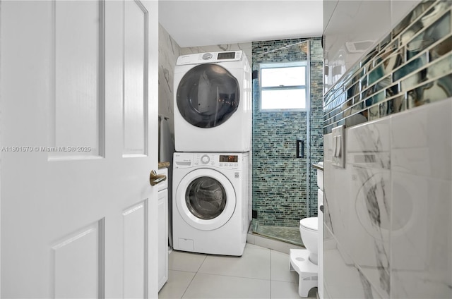 16750 NE 10th Ave Unit 314, North Miami Beach, FL 33162 - washroom featuring stacked washer and clothes dryer, tile walls, and light tile patterned floors