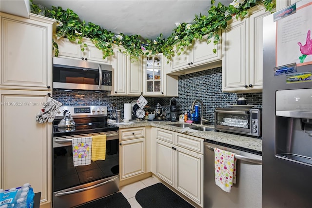 1100 Saint Charles Pl Unit 407, Pembroke Pines, FL 33026 - kitchen featuring stainless steel appliances, light tile patterned floors, backsplash, and light stone countertops