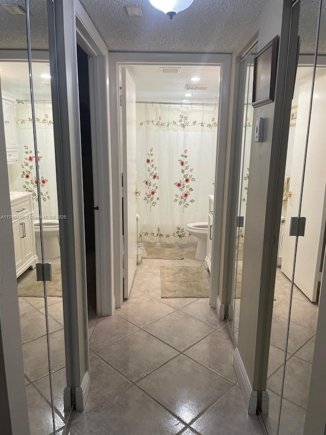 7680 NW 18th St Unit 107, Margate, FL 33063 - corridor featuring a textured ceiling and light tile patterned floors