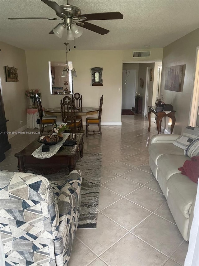 7680 NW 18th St Unit 107, Margate, FL 33063 - living room featuring light tile patterned floors, a ceiling fan, a textured ceiling, and baseboards