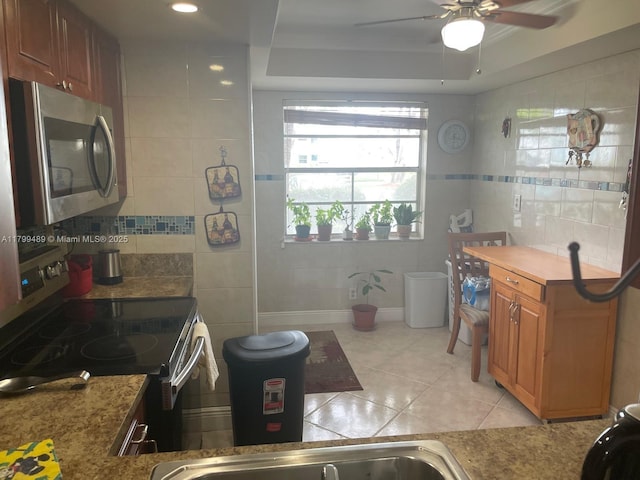 7680 NW 18th St Unit 107, Margate, FL 33063 - bathroom with a ceiling fan, tile walls, tile patterned flooring, a sink, and a tray ceiling