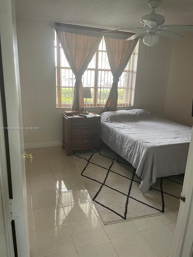 7680 NW 18th St Unit 107, Margate, FL 33063 - bedroom featuring light tile patterned flooring, baseboards, and ceiling fan
