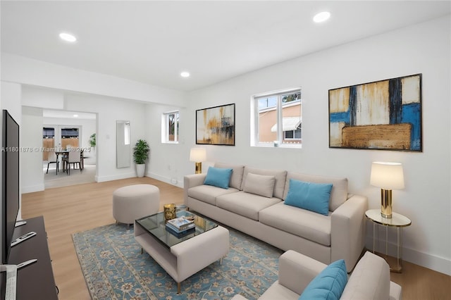 living room featuring light wood-style flooring, recessed lighting, and baseboards