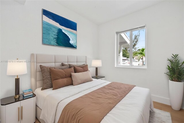 bedroom featuring wood finished floors and baseboards