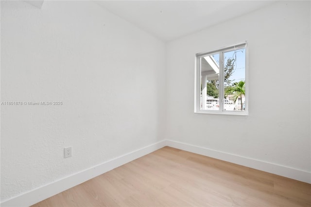 empty room featuring baseboards and light wood-style floors