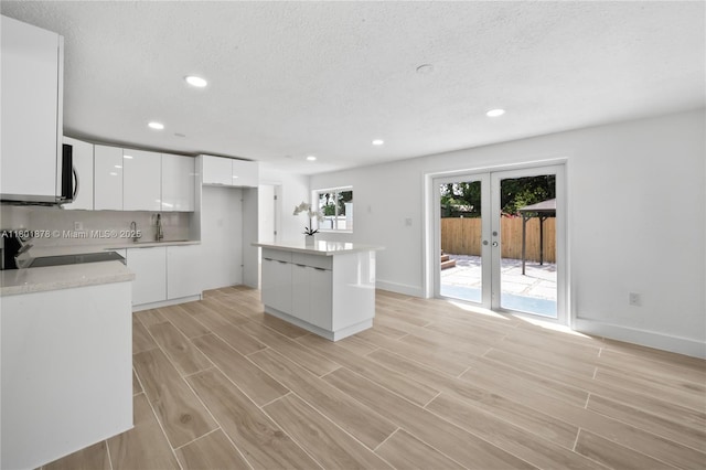 kitchen with modern cabinets, stove, white cabinets, light wood-type flooring, and recessed lighting