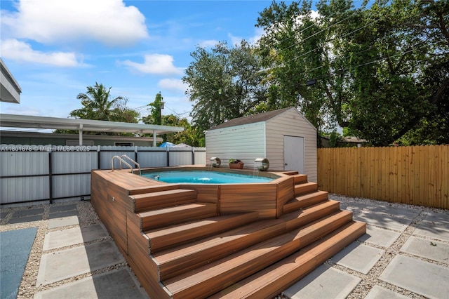 view of swimming pool with a fenced backyard, a shed, and an outbuilding