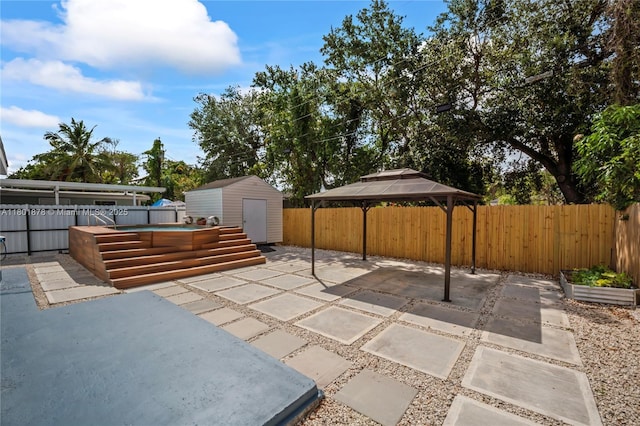 view of patio / terrace featuring a storage shed, a fenced backyard, an outbuilding, and a gazebo