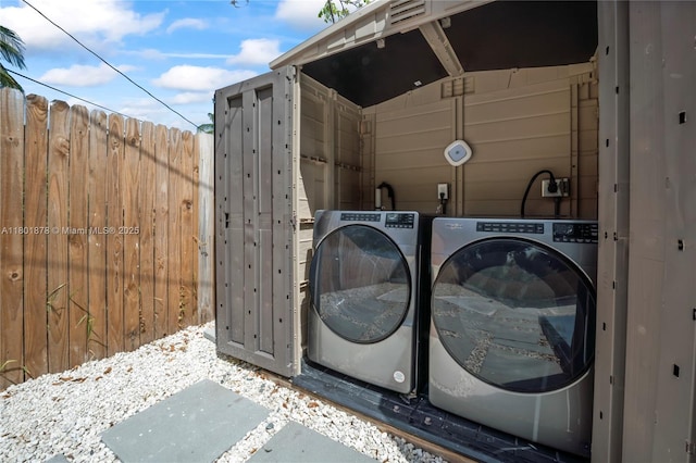 laundry area with washer and clothes dryer and wood walls