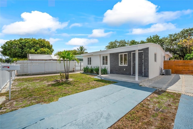 view of front of home featuring a patio, central AC, and stucco siding