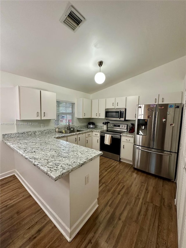 3828 NW 121st Ave, Sunrise, FL 33323 - kitchen featuring stainless steel appliances, a peninsula, a sink, white cabinetry, and lofted ceiling