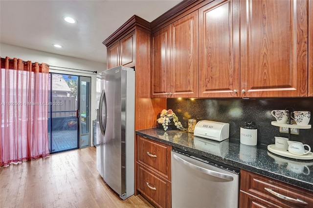 1951 SW 81st Ter, Davie, FL 33324 - kitchen featuring appliances with stainless steel finishes, brown cabinets, light wood-type flooring, decorative backsplash, and dark stone counters