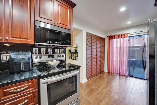 1951 SW 81st Ter, Davie, FL 33324 - kitchen with stainless steel appliances, light wood-type flooring, recessed lighting, dark stone countertops, and brown cabinets
