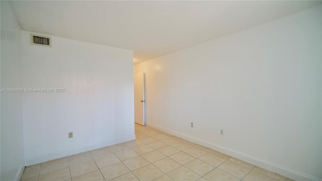 unfurnished room with light tile patterned floors and baseboards