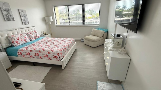 bedroom with wood finished floors and baseboards