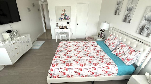 bedroom with wood finished floors and baseboards