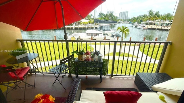 balcony with a water view and a dock