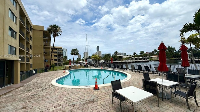 community pool with fence and a patio