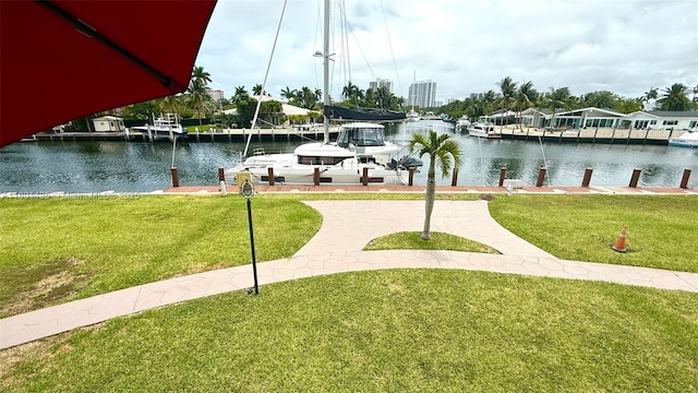 dock area featuring a water view, boat lift, and a yard