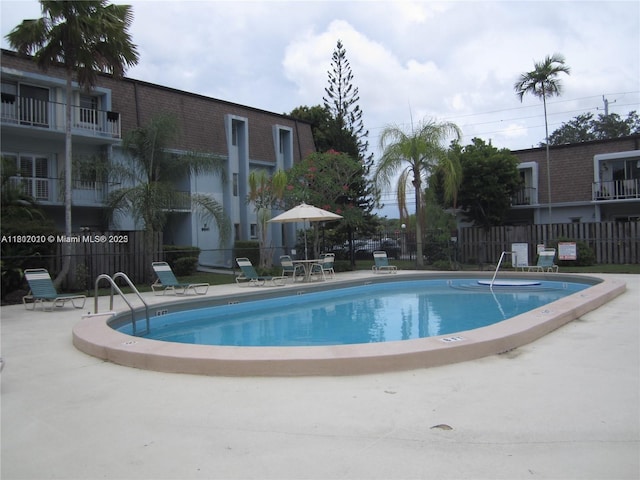 community pool featuring fence and a patio area