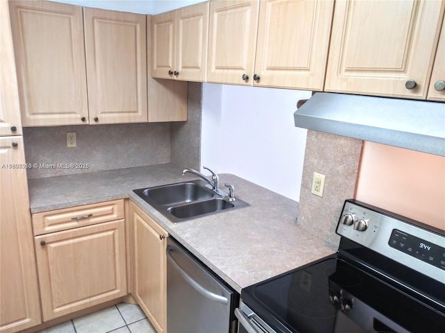 kitchen with appliances with stainless steel finishes, light brown cabinets, a sink, and light countertops