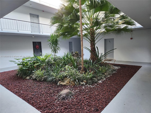 view of side of property featuring a balcony and stucco siding