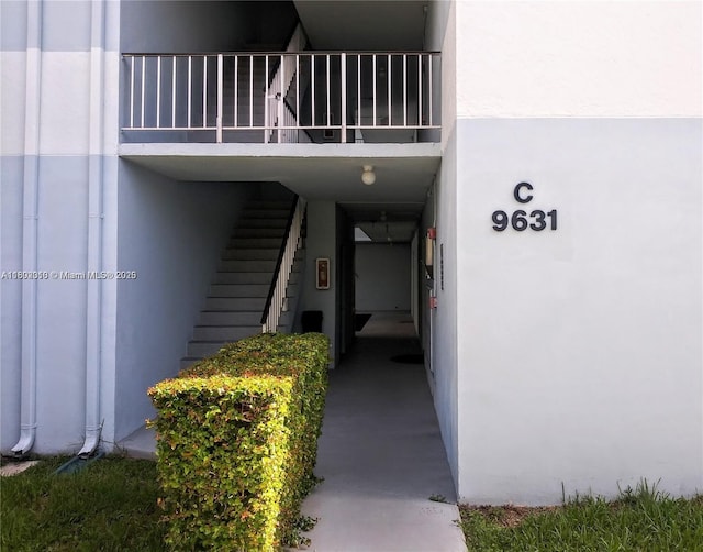 property entrance with a balcony and stucco siding