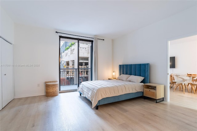 bedroom with light wood-style floors, access to outside, and baseboards