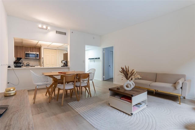 living area with light wood-type flooring and baseboards