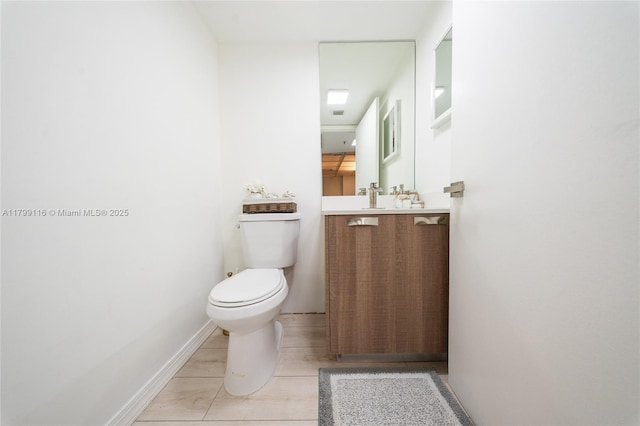 bathroom featuring toilet, vanity, and baseboards