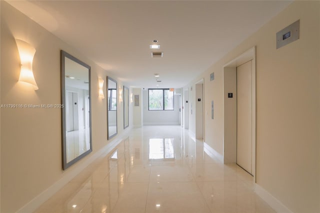 hall featuring elevator and baseboards