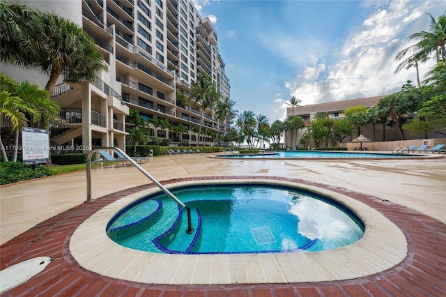 community pool featuring a hot tub