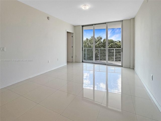 7875 NW 107th Ave Unit 306, Doral, FL 33178 - unfurnished room with a wall of windows, baseboards, and light tile patterned flooring