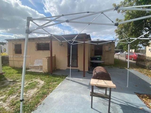 back of property with a patio area, stucco siding, and a lanai