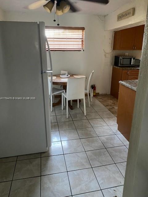dining area with ceiling fan and light tile patterned flooring