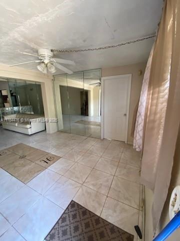 spare room featuring tile patterned flooring and a ceiling fan