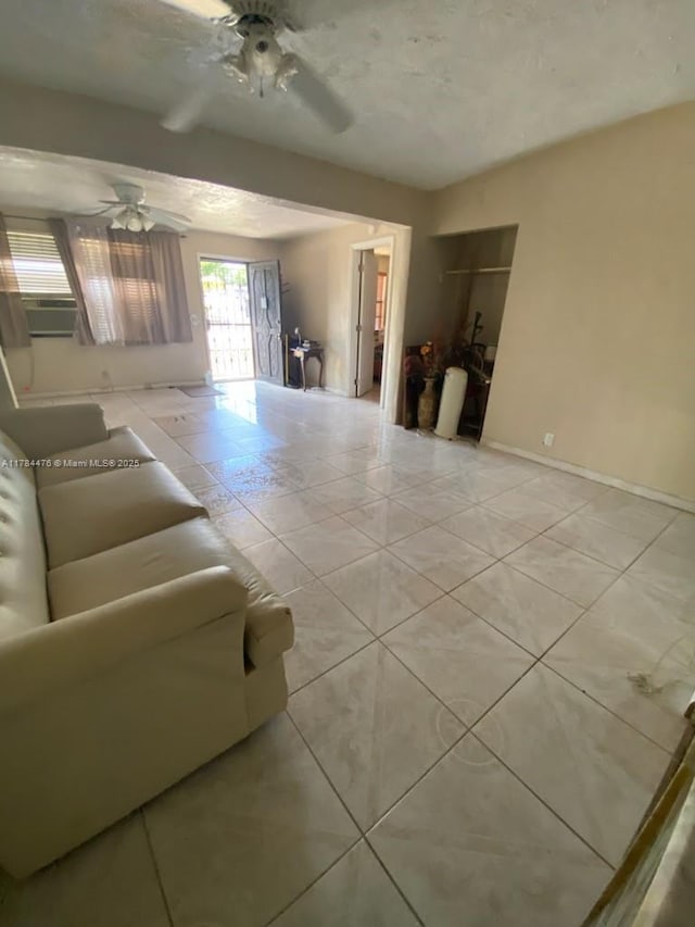 unfurnished living room with a ceiling fan and tile patterned floors
