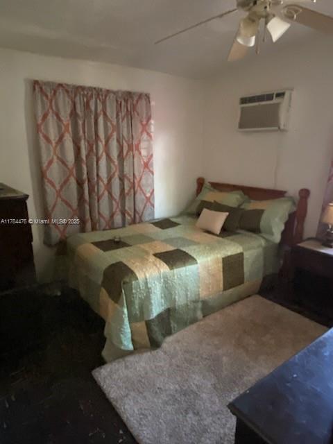 bedroom featuring a wall mounted air conditioner and ceiling fan