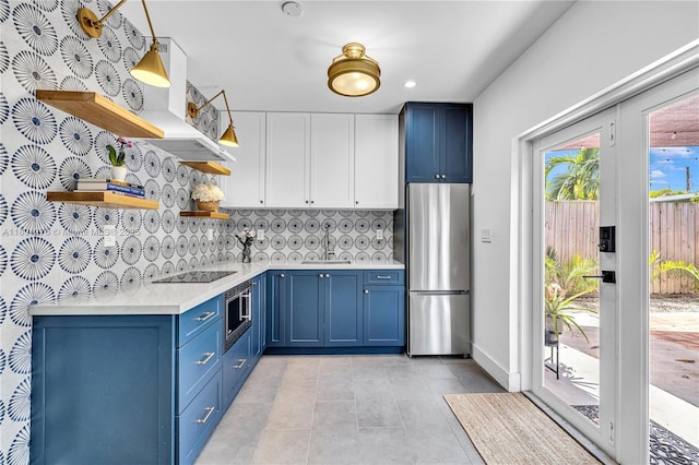 2801 SW 64th Ave, Miami, FL 33155 - kitchen featuring stainless steel appliances, blue cabinets, open shelves, light countertops, and tasteful backsplash