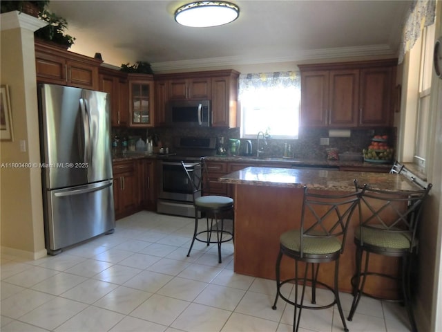 1593 NW 158th Ave, Pembroke Pines, FL 33028 - kitchen with appliances with stainless steel finishes, a breakfast bar area, tasteful backsplash, a peninsula, and ornamental molding