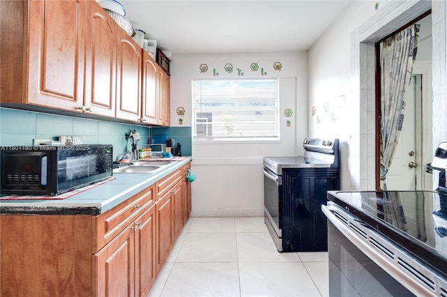 3050 NW 22nd Ct, Miami, FL 33142 - kitchen featuring stainless steel range with electric stovetop, black microwave, a sink, and light tile patterned floors