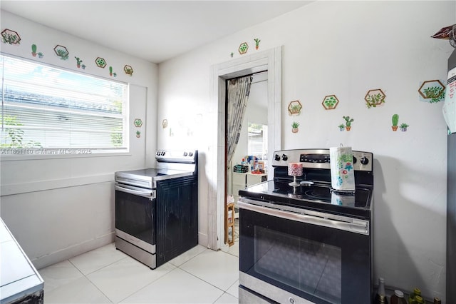 3050 NW 22nd Ct, Miami, FL 33142 - kitchen with stainless steel electric range, healthy amount of natural light, and light tile patterned floors