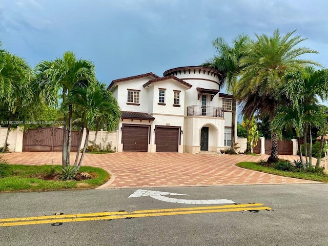 19994 SW 129th Ct, Miami, FL 33177 - mediterranean / spanish-style house featuring a balcony, a gate, a garage, stucco siding, and decorative driveway