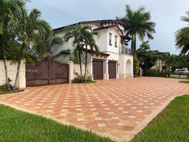 19994 SW 129th Ct, Miami, FL 33177 - view of front of house featuring a balcony, stucco siding, a gate, decorative driveway, and an attached garage
