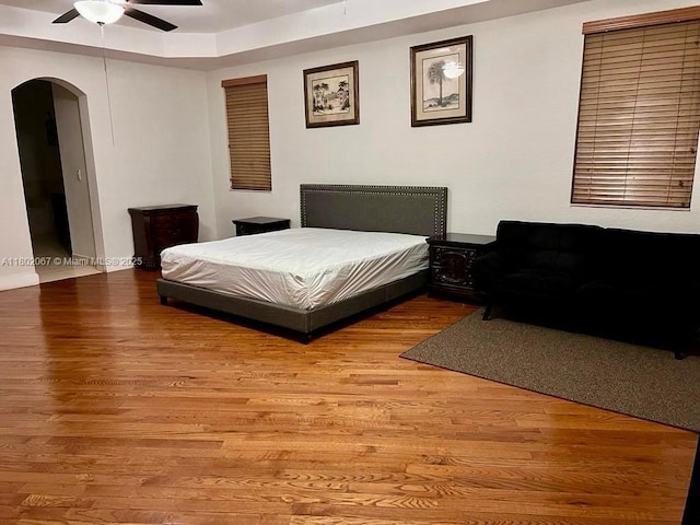 19994 SW 129th Ct, Miami, FL 33177 - bedroom with arched walkways, light wood-style flooring, a ceiling fan, and a tray ceiling