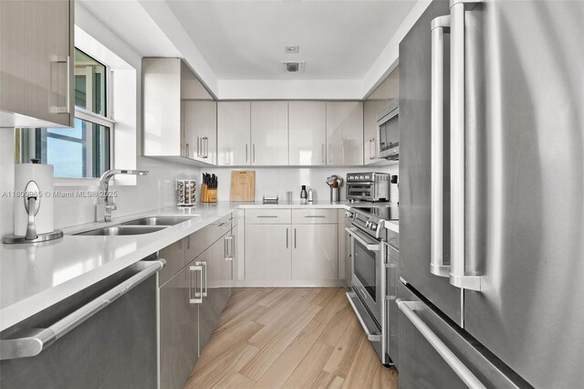 2475 Brickell Ave Unit 2002, Miami, FL 33129 - kitchen with stainless steel appliances, a sink, light wood-type flooring, and light countertops